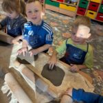 Chłopcy ugniatają gline