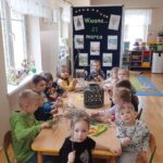 Dzieci dekorują gałązki kwiatkami