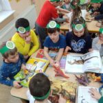 Dzieci oglądają książki o dinozaurach