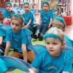 Dzieci siedzą na dywanie