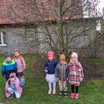 Dzieci-stojace-przy-kwitnacym-krzewie-magnolii