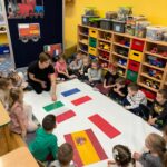 Dzieci wraz z Panią układają flagi