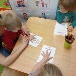Przedszkolaki odrysowywujący swoją dłoń