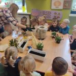 Przedszkolaki przy stole z sadzonkami