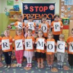 Przedszkolaki trzymają kartki z napisem stop przemocy