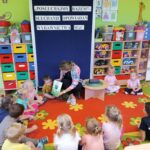 Nauczycielka pokazuje dzieciom ilustracje do opowiadania