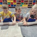 Dzieci wałkują glinę