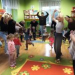 Przedszkolaki i ich rodzice pokazują grzybka