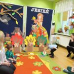 Przedszkolaki podczas zabawy dedaktycznej przy wykorzystaniu jesiennych drzew