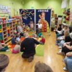 Przedszkolaki słuchają opowiadania czytanego przez nauczyciela