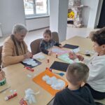 dzieci i seniorzy wyklejają bałwanki