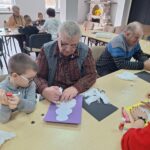 dzieci i seniorzy wyklejają bałwanki