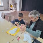 dzieci i seniorzy wyklejają bałwanki