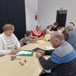 dzieci i seniorzy wyklejają bałwanki