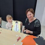 dzieci i seniorzy wyklejają bałwanki