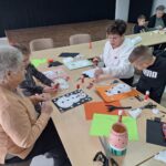 dzieci i seniorzy wyklejają bałwanki