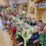 Dzieci siedzą przy stoliku, poczęstunek