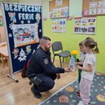 dziewczynka z chłopcem dziekują policjantowi za przekazanie cennych informacji