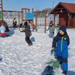 dzieci bawią się śniegiem