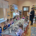 Dzieci słuchają prowadzącej warsztaty