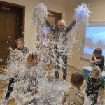 Pani-bawi-sie-z-dziecmi-pocietymi-papierkami-jako-snieg