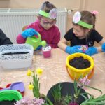 dzieci z oddziału stokrotki sadzą kwiatki