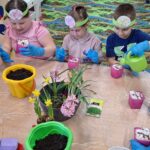 dzieci z oddziału stokrotki sadzą kwiatki