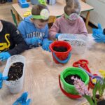 dzieci z oddziału stokrotki sadzą kwiatki