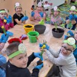 dzieci z oddziału stokrotki sadzą kwiatki