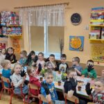 Dzieci z oddziału Biedronek przystolikach w oczekiwaniu na sadzenie roślin