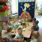 Dzieci z oddziału Żuczki przy stole przed zajęciami z sadzenia