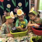 Dziewczynki przesadzaja kwiatki