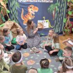 Nauczycielka czyta ciekawostki o dinozaurach