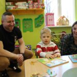 Przyszły przedszkolak z rodzicami przy stoliku z układankami