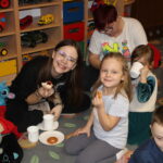 Rodzice i dzieci jedzą pączki