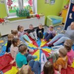 dzieci siedzą na chuście