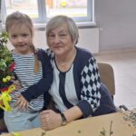 dzieci wraz z seniorami wykonują wielkanocne palmy