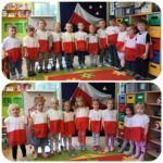 Dzieci z oddziału Żuczki w biało-czerwonych narzutach przy tablicy demonstracyjnej