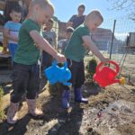 Chlopcy-podlewaja-posiane-nasionka