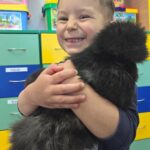 Chlopiec-przytula-czarna-kurke