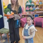 Dziewczynka wręcza prowadzącej warsztaty kwiat