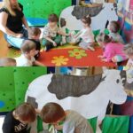 Przedszkolaki doją krówkę.