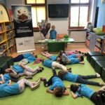 Dzieci leżą na dywanie w bibliotece