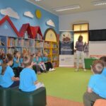 Dzieci siedzą w bibliotece