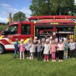 Dzieci stoją przed wozem ratowniczo gaśniczym