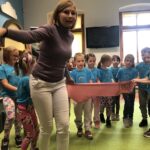 Dzieci z pisarką przedstawiają scenkę teatralną