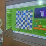 Dziewczynka-robi-szach-mat-na-tablicy-multimedialnej