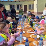 dzieci jedzą kiełbaski