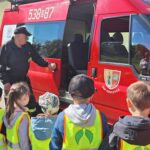 dzieci jadą wozem strażackim