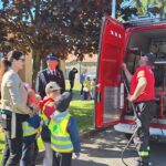 dzieci jadą wozem strażackim